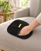 Black mesh pet-hair mitt demonstrated on a fabric chair cushion